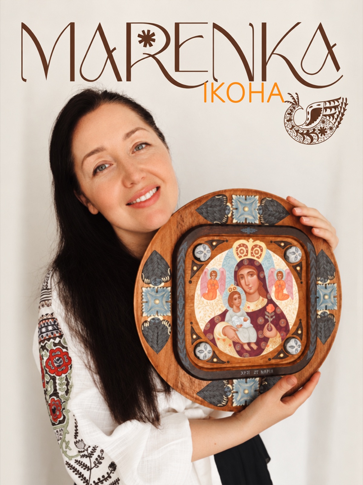 Мар’яна Фляк тримає ікону Богородиці в дерев’яній рельєфній рамі